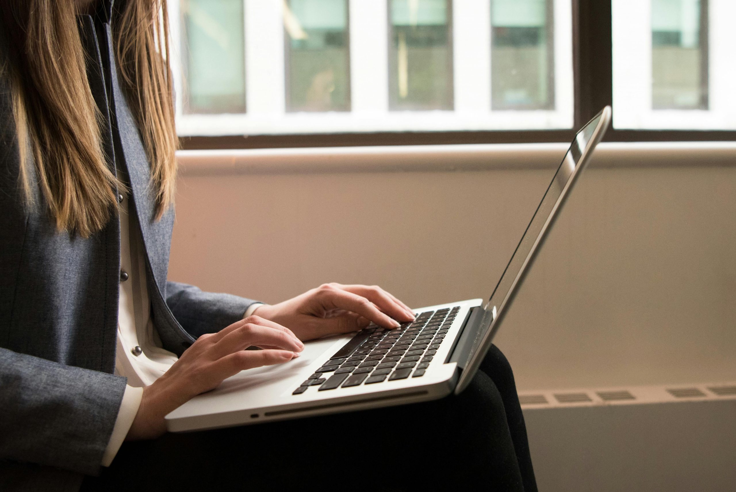 a woman sitting on a chair using a laptop