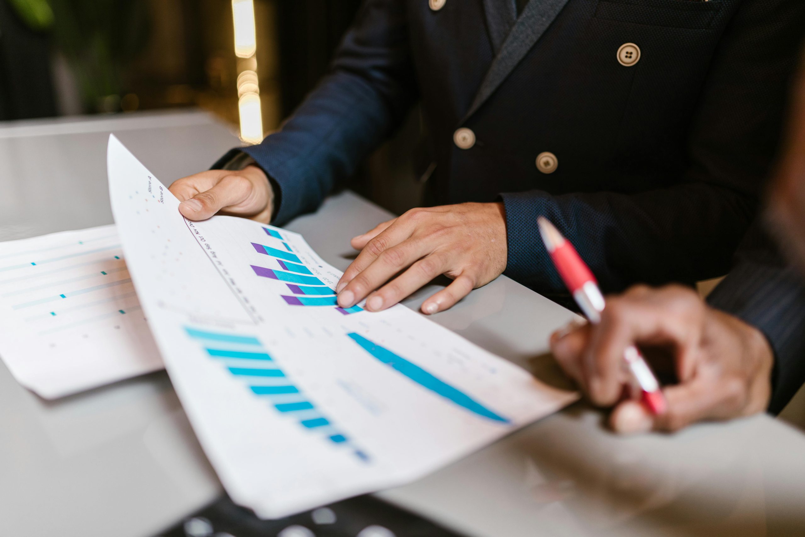 a person holding a pen and looking at a graph